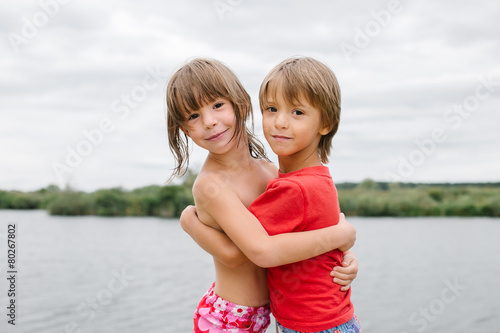 Fraternal twins hugging at the beach