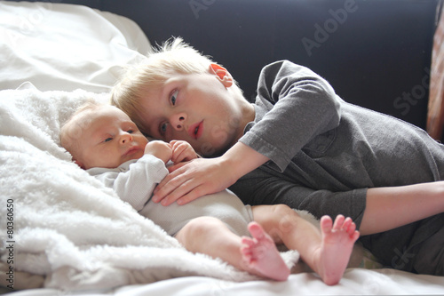 Big Brother Lovingly Playing with Newborn Baby Sister