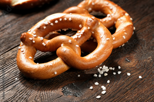 Fresh pretzels with sea salt close-up on dark board background