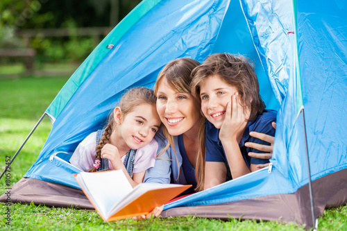Children With Mother Holding Book In Tent