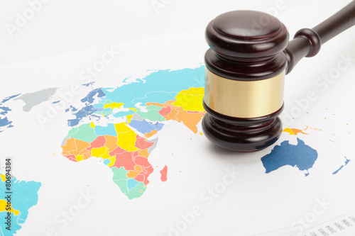 Wooden judge's gavel over colorful world map