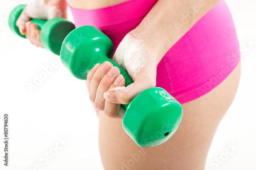 Fitness girl with green dumbbells