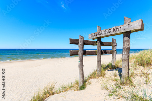Wooden trail sign on beach in Slowinski National Park, Poland