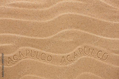 Acapulco inscription on the wavy sand