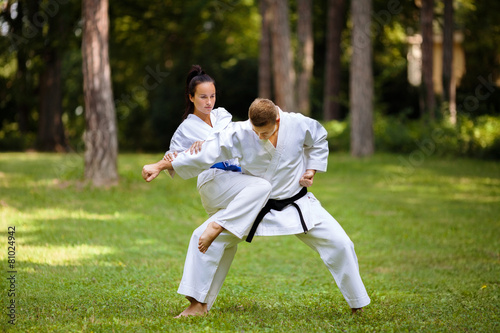 Two young Martial Arts fighters practicing in nature