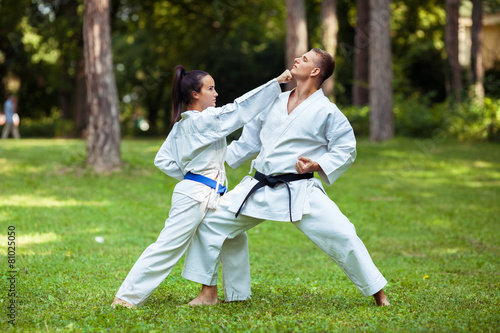 Two young people practicing martial arts outdoors