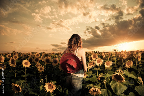 cowgirl at sunflowers farm field sunset