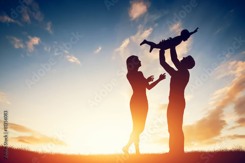 Happy family together, parents with their little baby at sunset