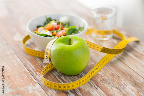 close up of green apple and measuring tape