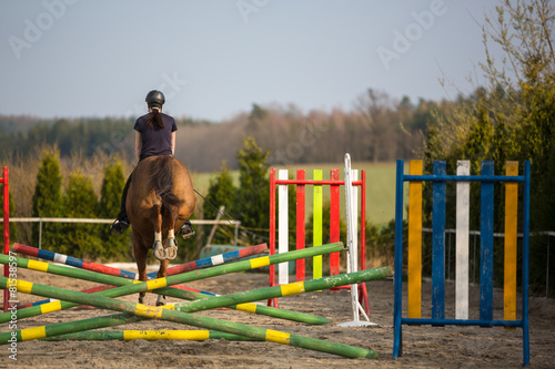 Young woman show jumping with horse