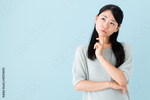 young asian woman thinking on blue background
