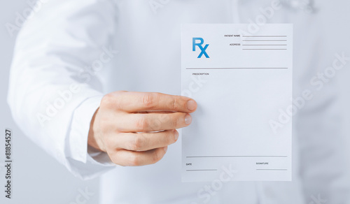 male doctor holding rx paper in hand