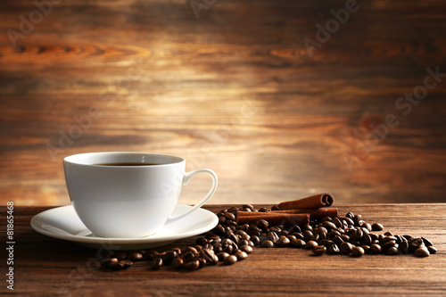 Cup of coffee with grains and cinnamon sticks