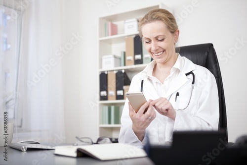 Happy Woman Physician Chatting at her Mobile Phone