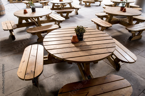 Tavolini rotondi e sedute in doghe di legno da esterno