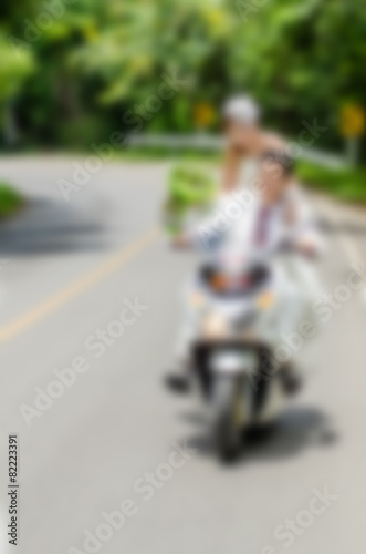 Blurry background, Just married. Groom and bride on the motorcyc