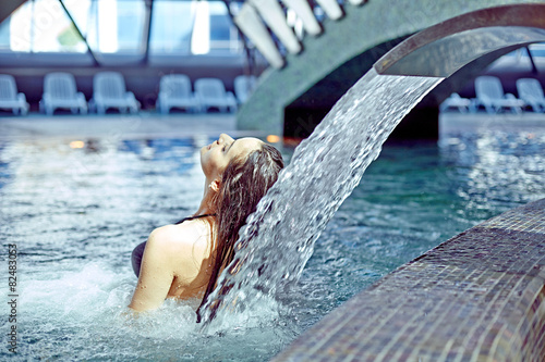 beautiful woman in waterfall jet, spa hydrotherapy