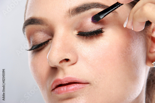 beautiful young model applying some eyeshadow