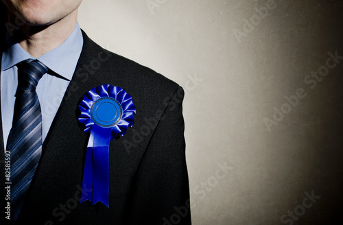 Election candidate with blue rosette.