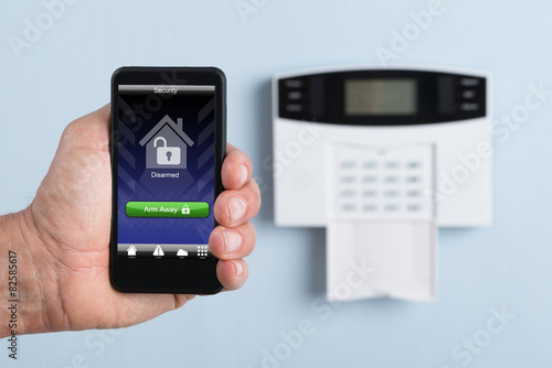 Person Holding Remote Control Of Security System