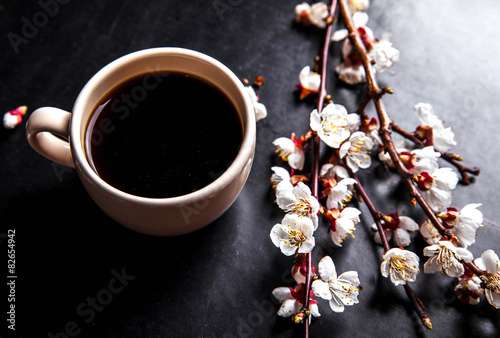 cup of coffee and pink cherry blossoms. flowers