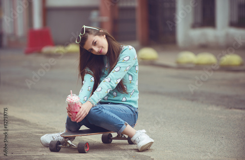Beautiful young woman posing with a skateboard, fashion