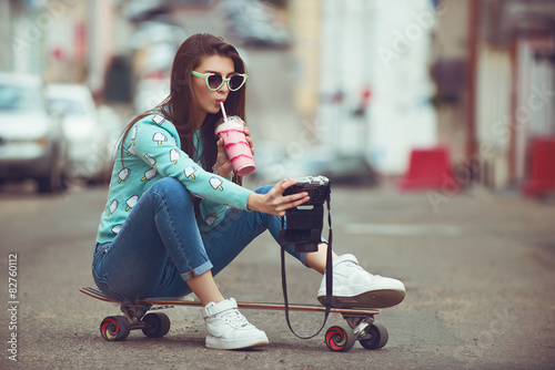 Beautiful young woman posing with a skateboard, fashion