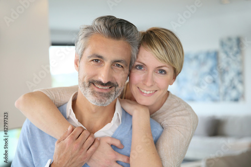 Smiling middle-aged couple standing in brand new home