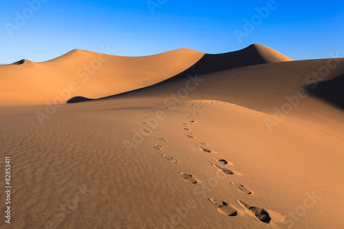 footprints on the hot sand in the desert