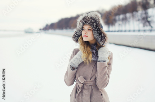 Portrait of a beautiful woman dressed a coat and fur hat in the