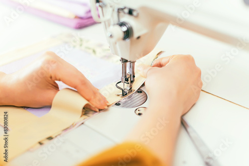 Woman's hands working on sewing machine.