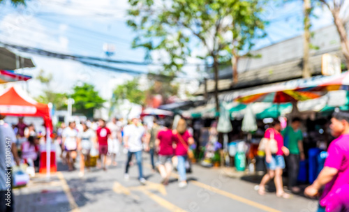 Blurred background : people shopping at market fair in sunny day