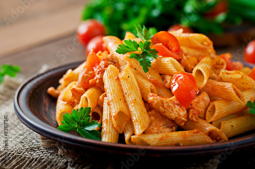 Penne pasta in tomato sauce with chicken, tomatoes