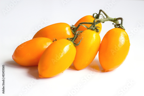 Cluster yellow tomato on light wooden texture