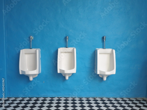  white urinals in men's bathroom