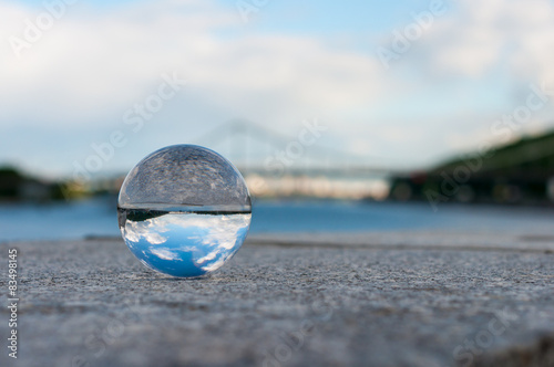 Glass transparent ball on bridge background and grainy surface