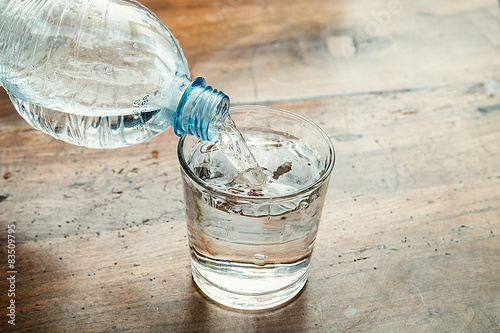 blue water bottle poured into a clear glass