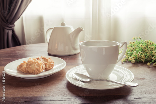 Cup of tea with teapot and cookies on table, vintage style