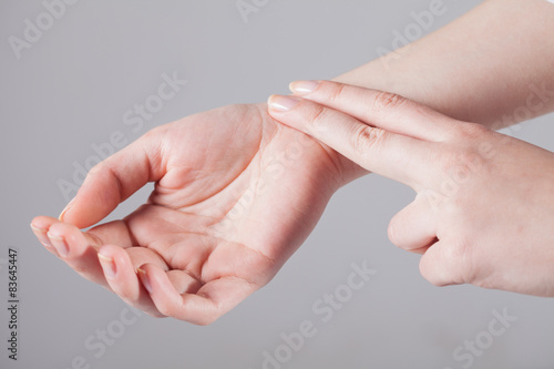 Women listen to the pulse of the hands on a white background