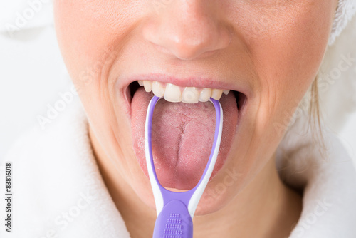Woman Using Tongue Cleaner