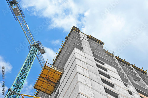 Crane and building construction site against blue sky