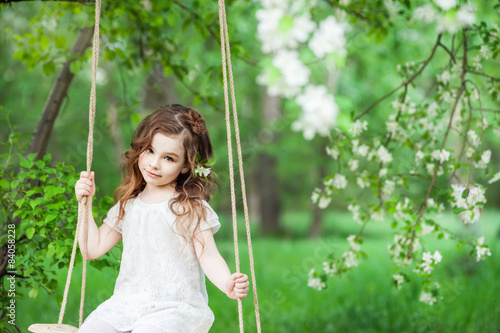 Portrait beautiful little girl near blossoming apple-tree