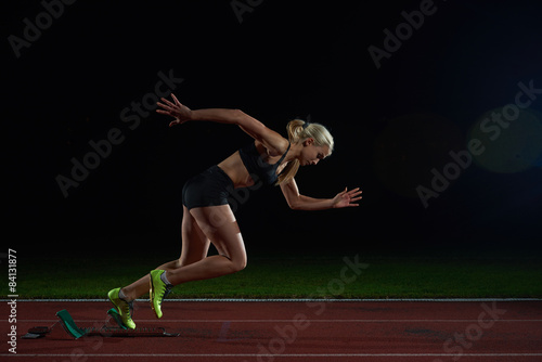 woman sprinter leaving starting blocks