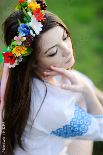 girl with freckles on her face in a Ukrainian shirt and floral b