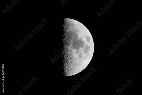 Half moon or first quarter phase in a black sky.