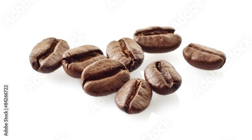 Scattered coffee beans on white