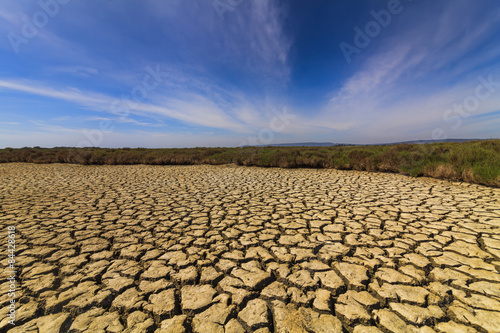 Dry cracked earth under the blue sky. Drought.