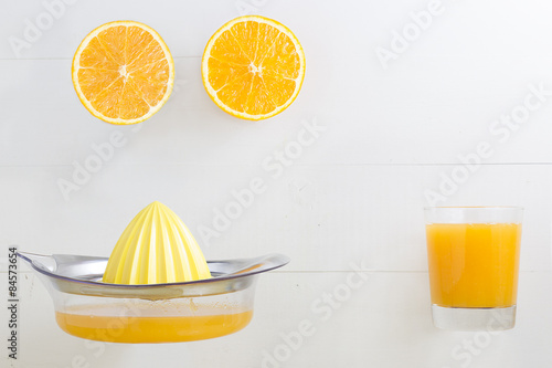 Halved orange with orange juice glass and squeezer with blank sp