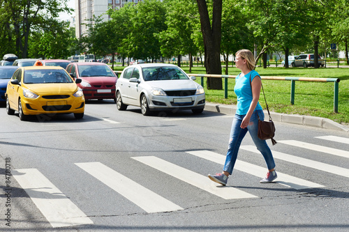 Woman crossing street at pedestrian crossing