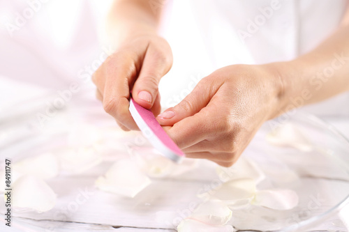 Manicure, kobieta piłuje paznokcie